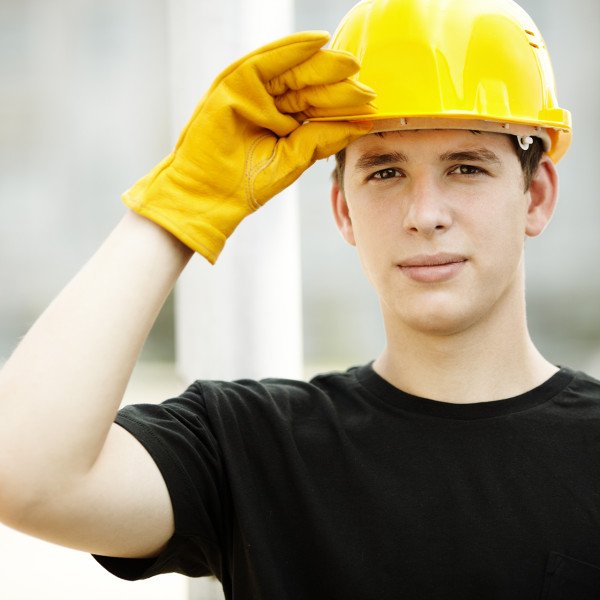 Young worker on construction site, selective focus on face